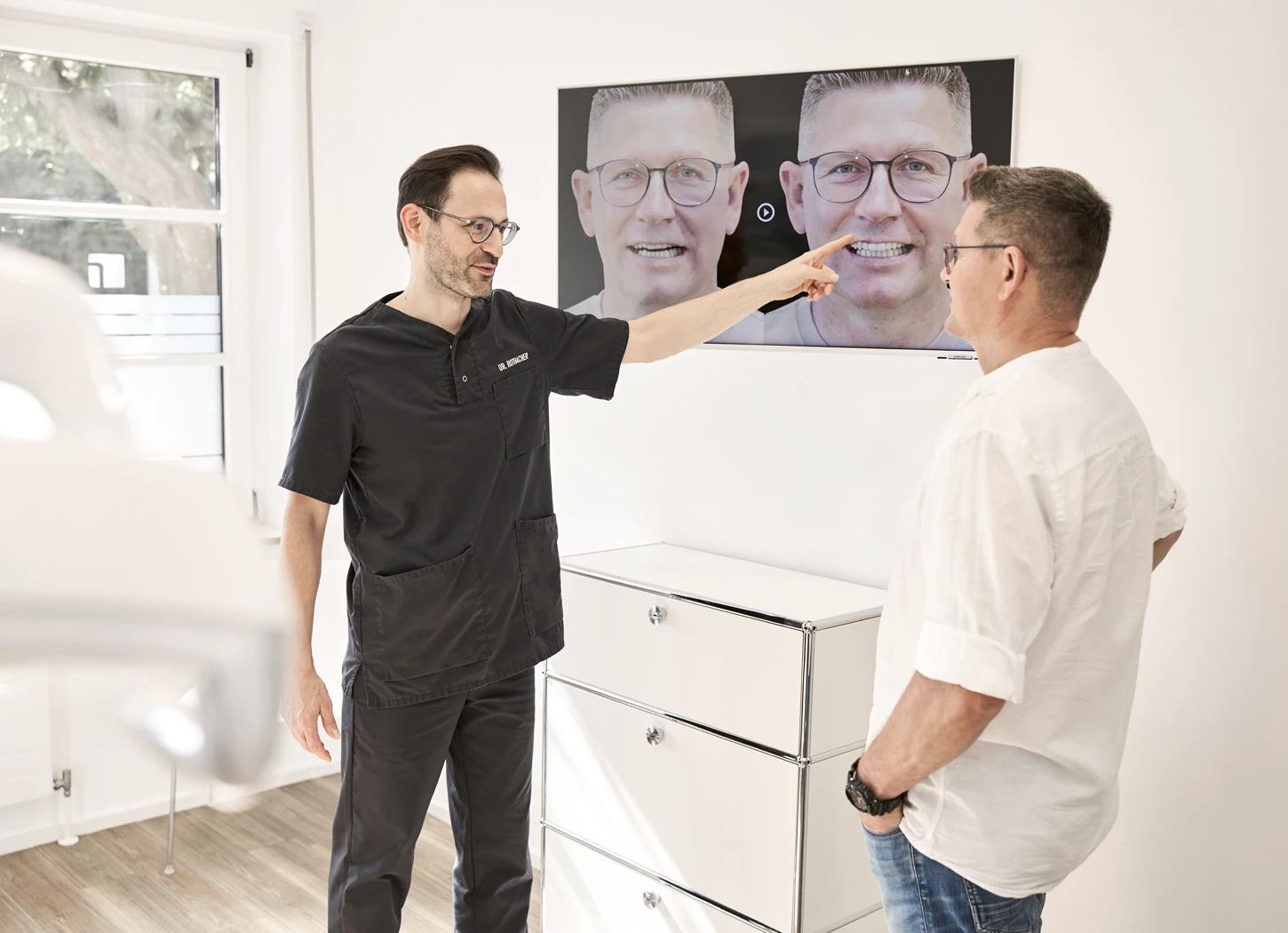 Zahnarzt zeigt Patient auf Bildschirm eine Zahnbehandlung in moderner Praxis bei Dr. Rothacher & Kollegen.